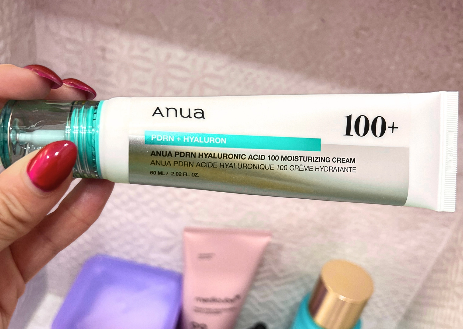 Hand holding product Tube of our favorite PDRN product in Korean Skincare is this Anua 100 PDRN + Hyaluron