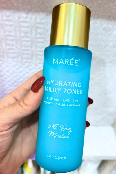 close up photo of hand holding product maree hydrating milky toner with pdrn collagen and hyaluronic acid