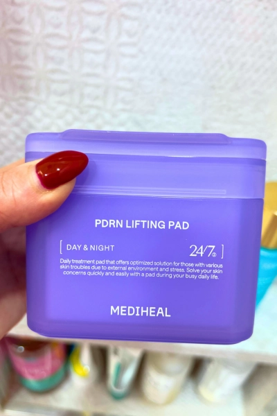 close up photo of hand holding product pdrn lifting pads by mediheal